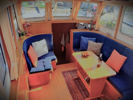 The saloon looks spacious and has a large sofa, but opposite there is another corner seat. The large windows give a good view into the harbour.