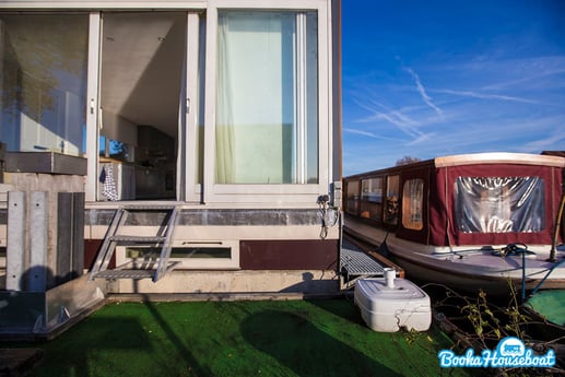 La terraza con el barco salón atracado al lado.