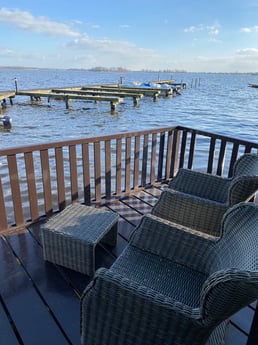 View from balcony with 2 seating areas and table and extra bench