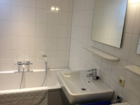 Das Badezimmer verfügt über eine Badewanne sowie eine separate Dusche und Toilette.