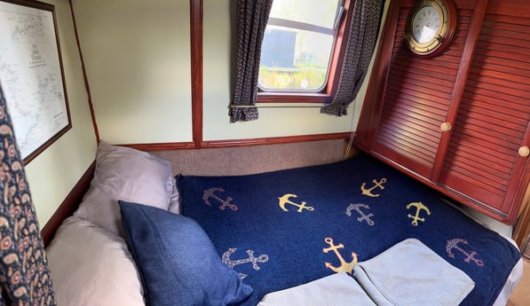The bedroom has a 4ft double bed. It is 6ft 3" long, and the end of the bed continues under the wardrobe.