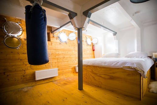 La chambre principale avec lit Queen size et hublots.