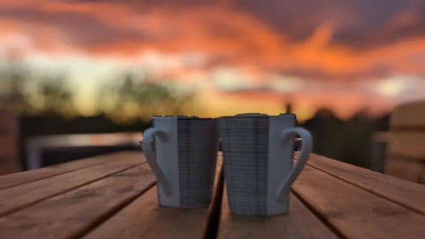 Kopjes thee bij zonsondergang op het dakterras