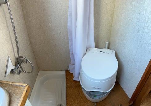 Kleine schoenenkamer met chemisch toilet