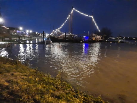 Nachtleven in de Oosthaven, tijdens vloed (200 meter); verlichte boot is Opoe (Oma) Sientje, de dichtstbijzijnde bar, het hele jaar geopend. In de zomer is er buiten een groot terras.