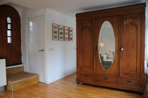 Geräumiges Zimmer, antiker Schrank fungiert als Raumteiler. Holzboden mit Fußbodenheizung.