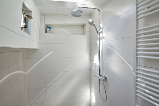 salle de bain principale avec douche à effet pluie, lavabo double vasque, baignoire et haut-parleur de plafond